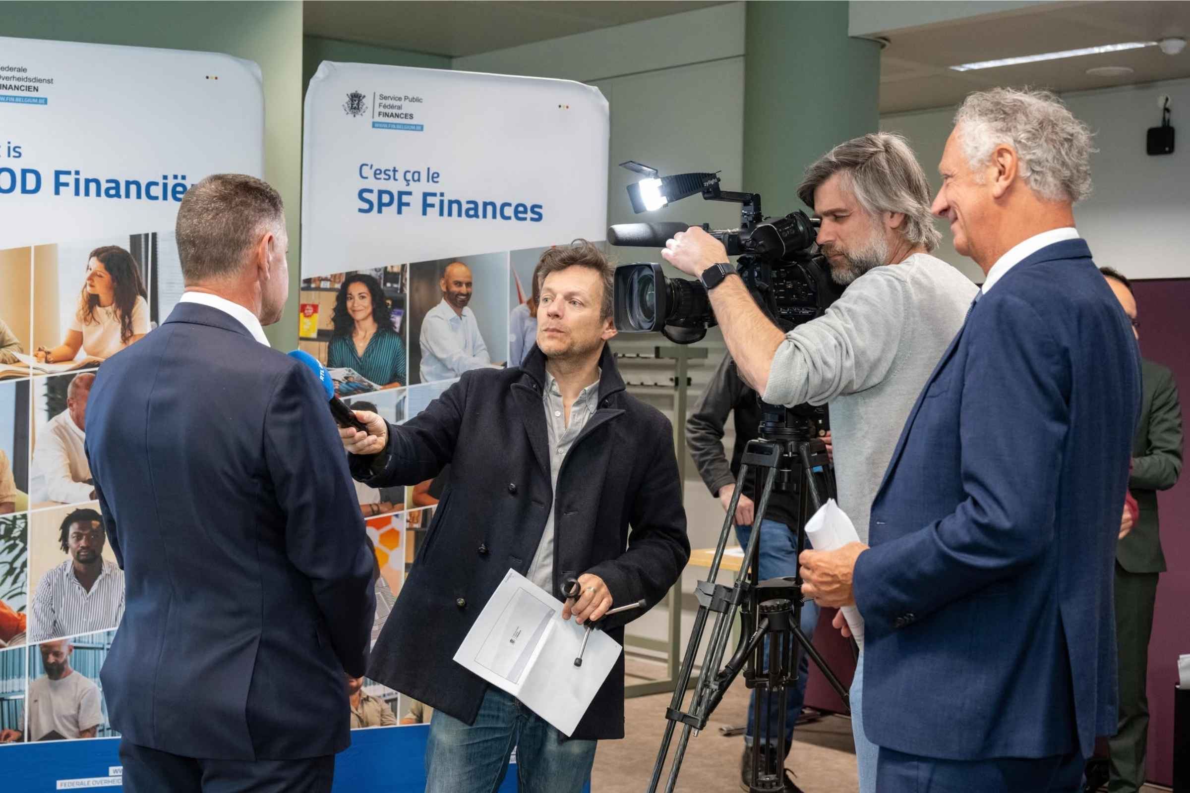 Des journalistes interviewant un fonctionnaire du SPF Finances